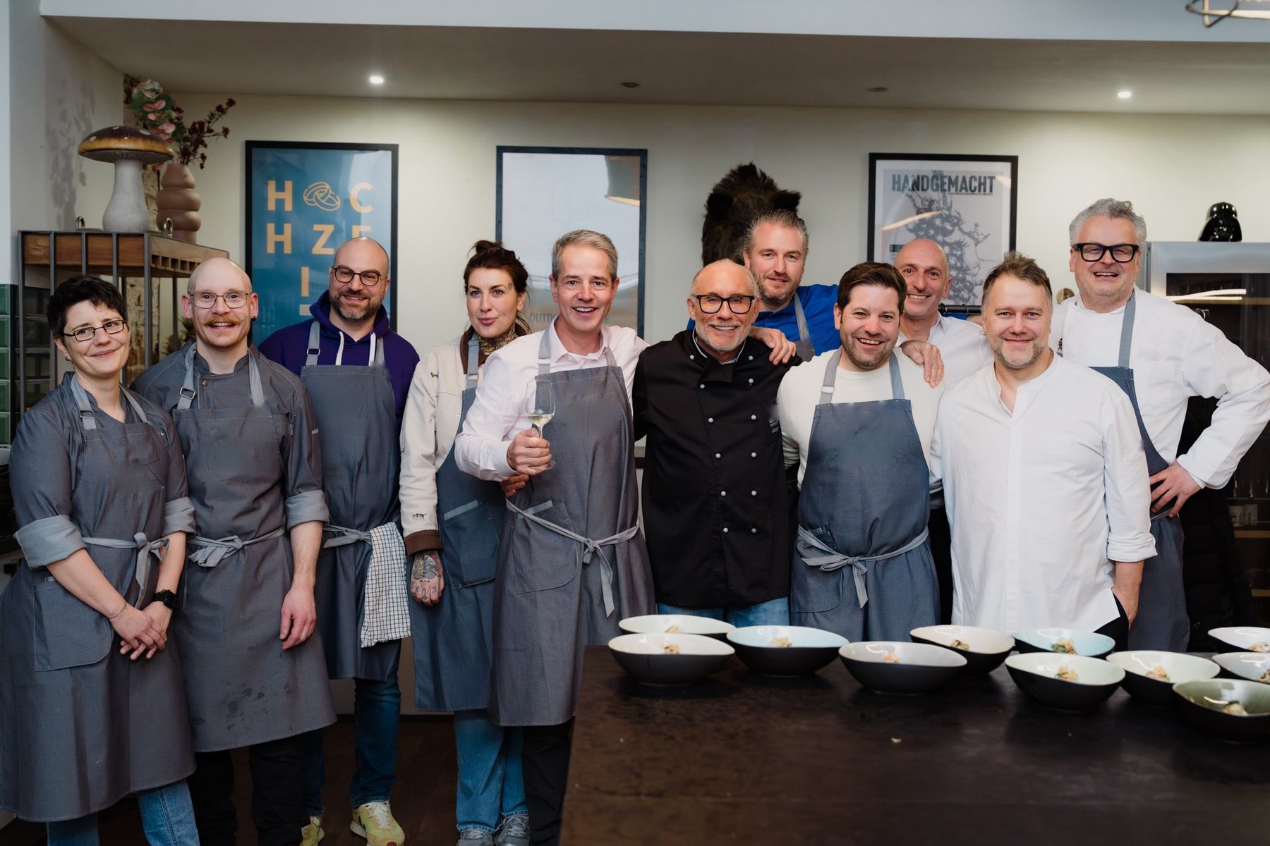 Gruppenbild von Köchinnen, Köchen und Gastronomiefachleuten in Schürzen nach einem gemeinsamen Kochevent